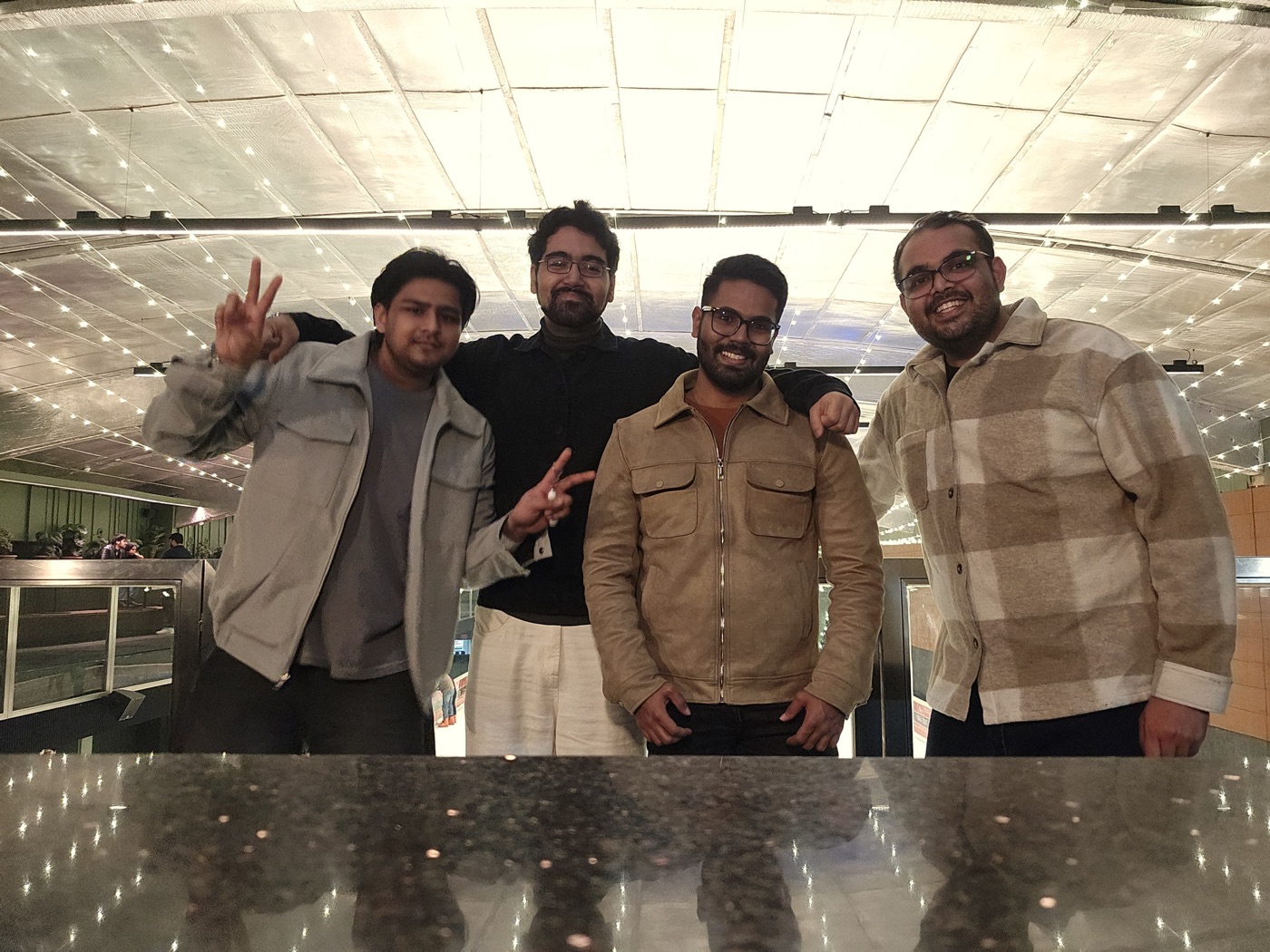 Akshat with friends under a mirrored ceiling