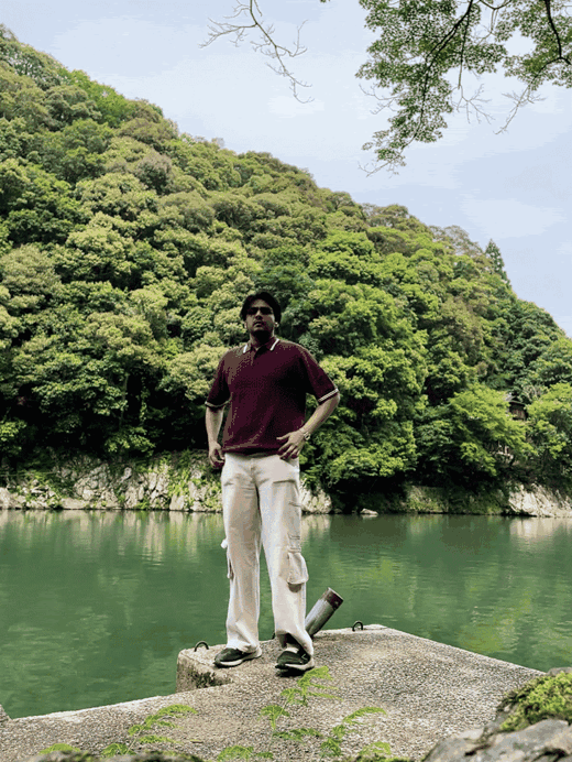 Akshat beside a lake surrounded by trees
